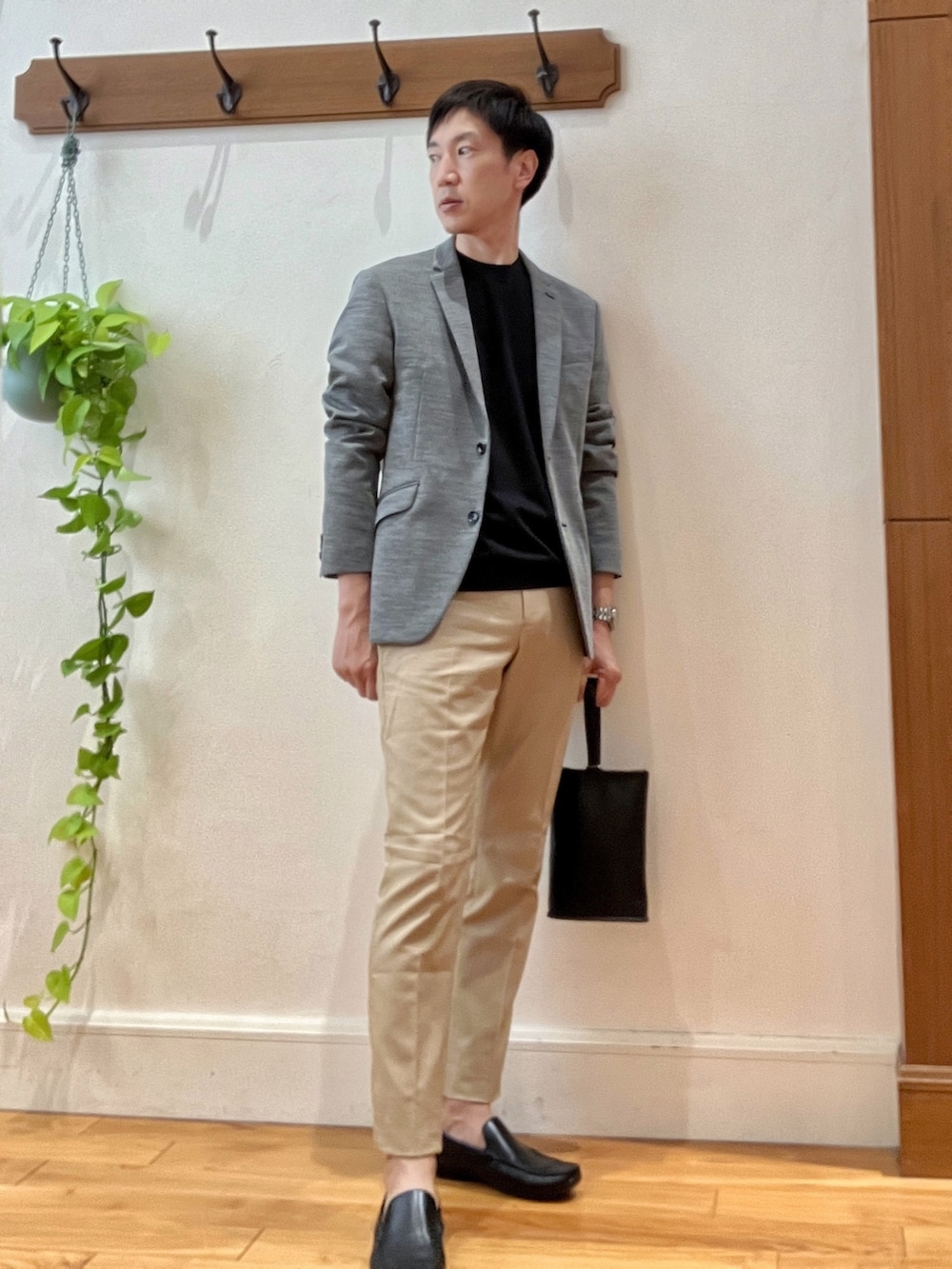 グレー系のテーラードジャケット、ブラック系のTシャツ/カットソー、ブラック系のハンドバッグを着用したメンズの秋コーディネートの2枚目の写真