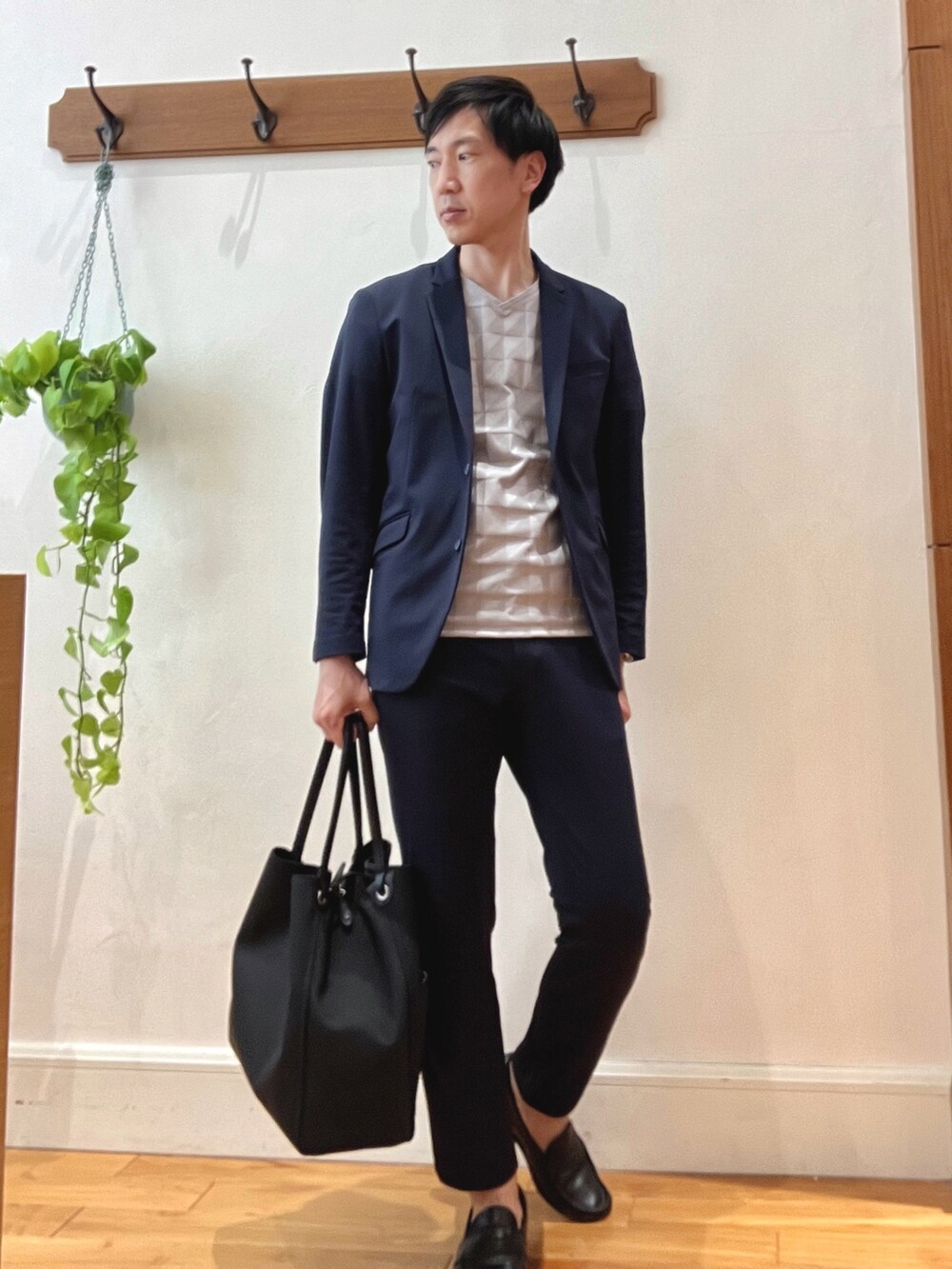 ブラック系のトートバッグ、ベージュ系のTシャツ/カットソー、ブルー系のテーラードジャケットを着用したメンズの春コーディネートの2枚目の写真