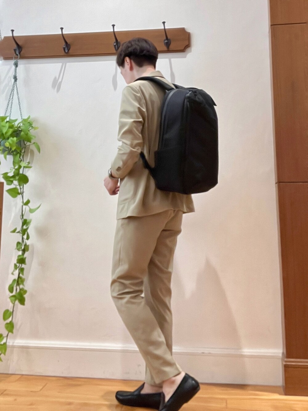 ベージュ系のテーラードジャケット、ブルー系のTシャツ/カットソー、ブラック系のバックパック/リュックを着用したメンズの春コーディネートの4枚目の写真