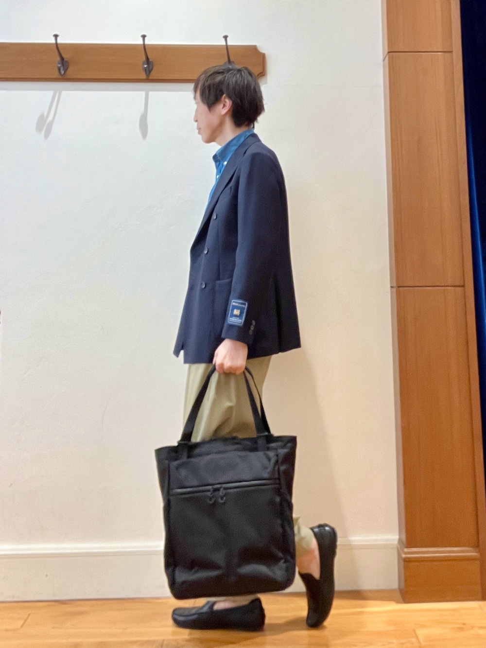 ブルー系のテーラードジャケット、ブラック系のトートバッグを着用したメンズの春コーディネートの5枚目の写真