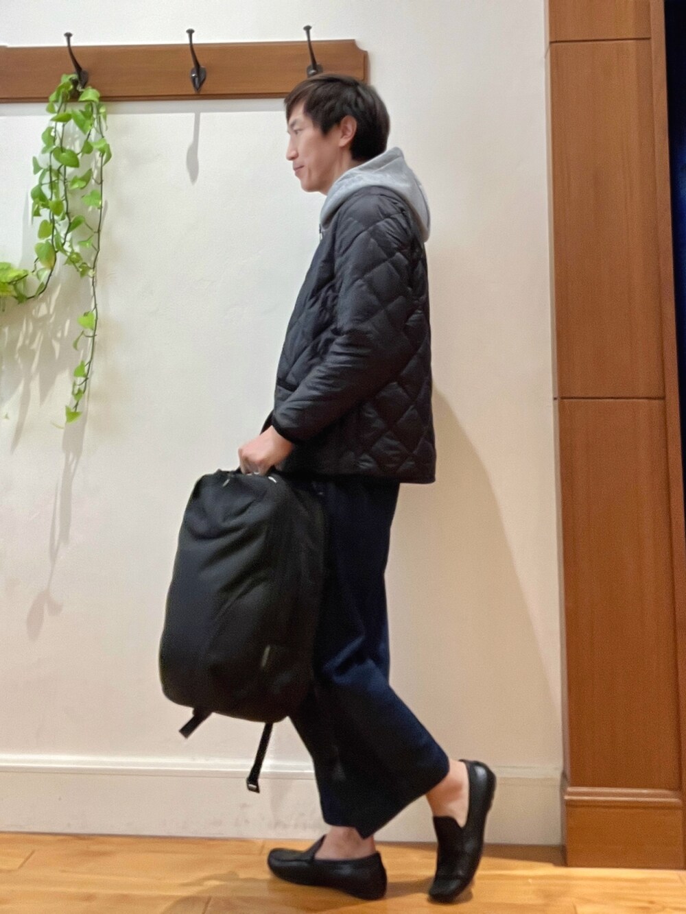 ブラック系のダウンジャケット/コート、グレー系のパーカー、ブラック系のバックパック/リュックを着用したメンズの秋コーディネートの3枚目の写真