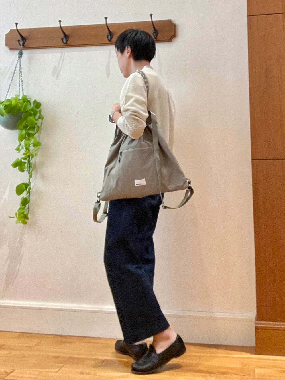 ベージュ系のカーディガン/ボレロ、グリーン系のトートバッグ、ホワイト系のTシャツ/カットソーを着用したメンズの春コーディネートの3枚目の写真