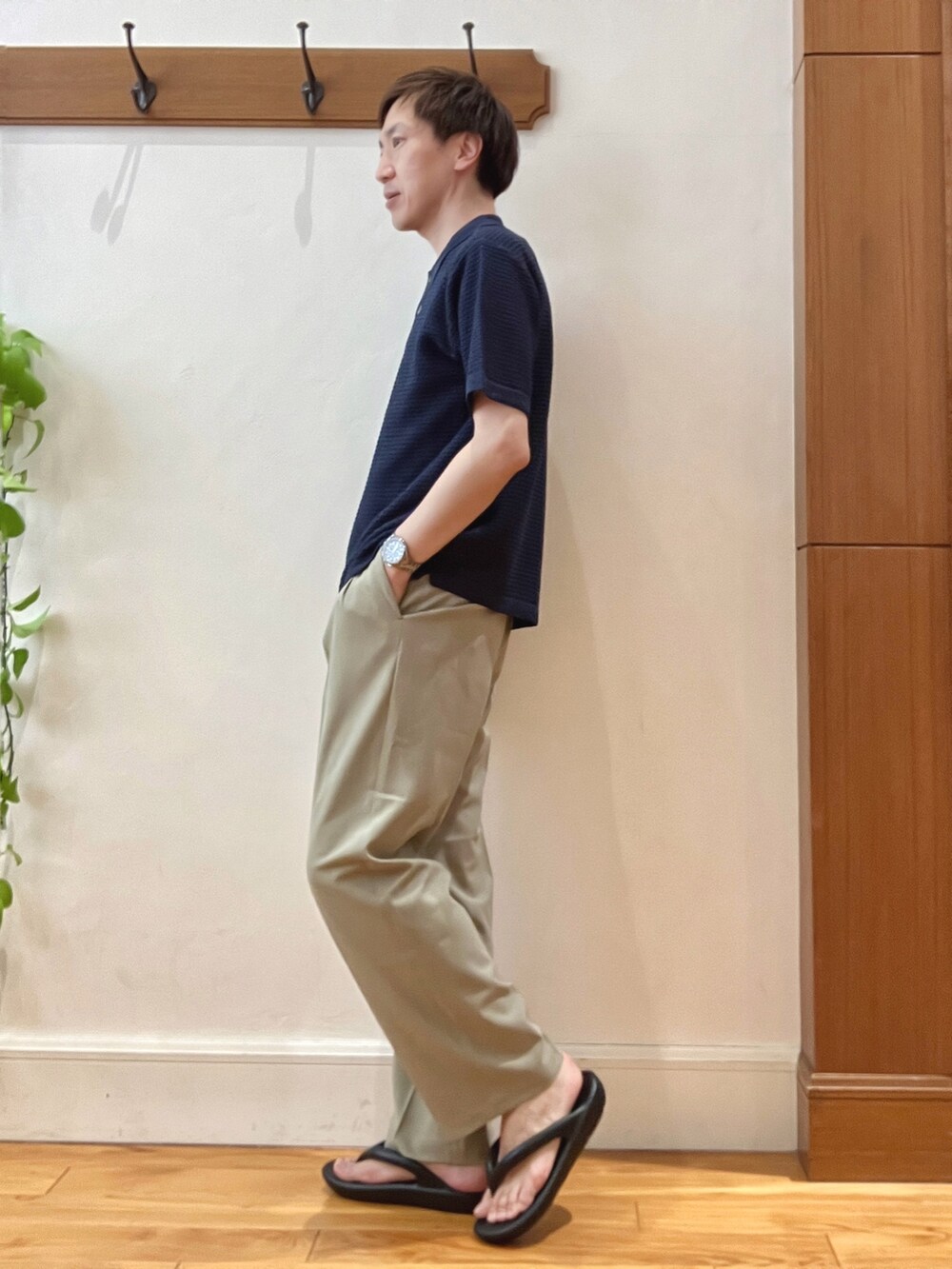 ブルー系のポロシャツ、ベージュ系のその他パンツ、ブラック系のバックパック/リュックを着用したメンズの春コーディネートの4枚目の写真