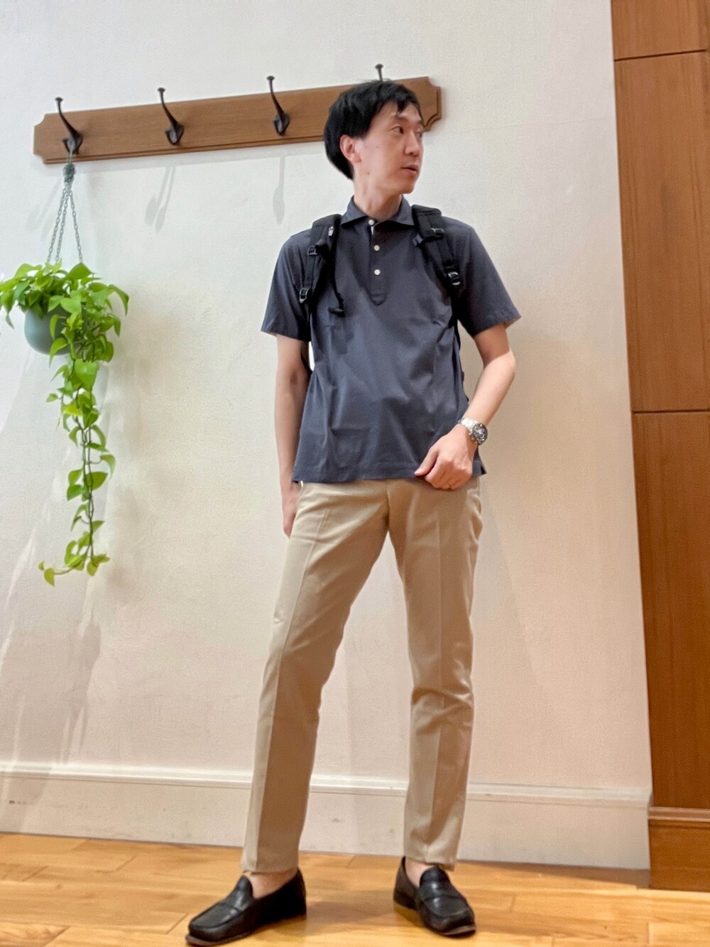 グレー系のポロシャツ、ブラック系のバックパック/リュック、ベージュ系のその他パンツを着用したメンズの春コーディネートの2枚目の写真