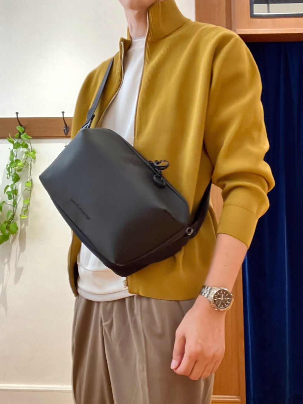 イエロー系のニット/セーター、ホワイト系のTシャツ/カットソー、ブラック系のショルダーバッグを着用したメンズの秋コーディネートの8枚目の写真