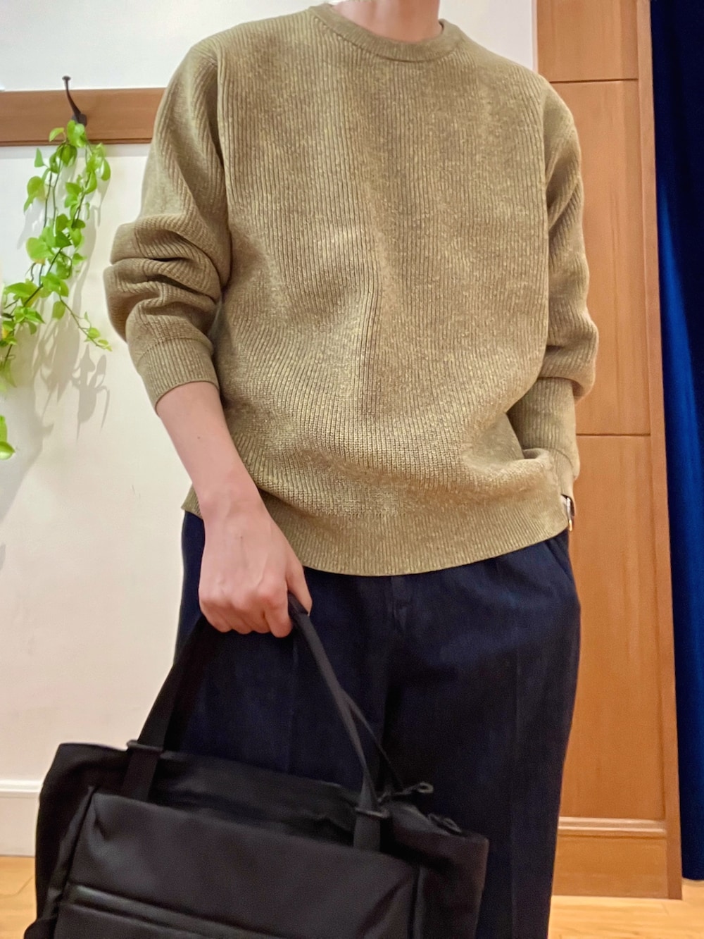 イエロー系のニット/セーター、ブルー系のデニムパンツ、ブラック系のトートバッグを着用したメンズの冬コーディネートの8枚目の写真