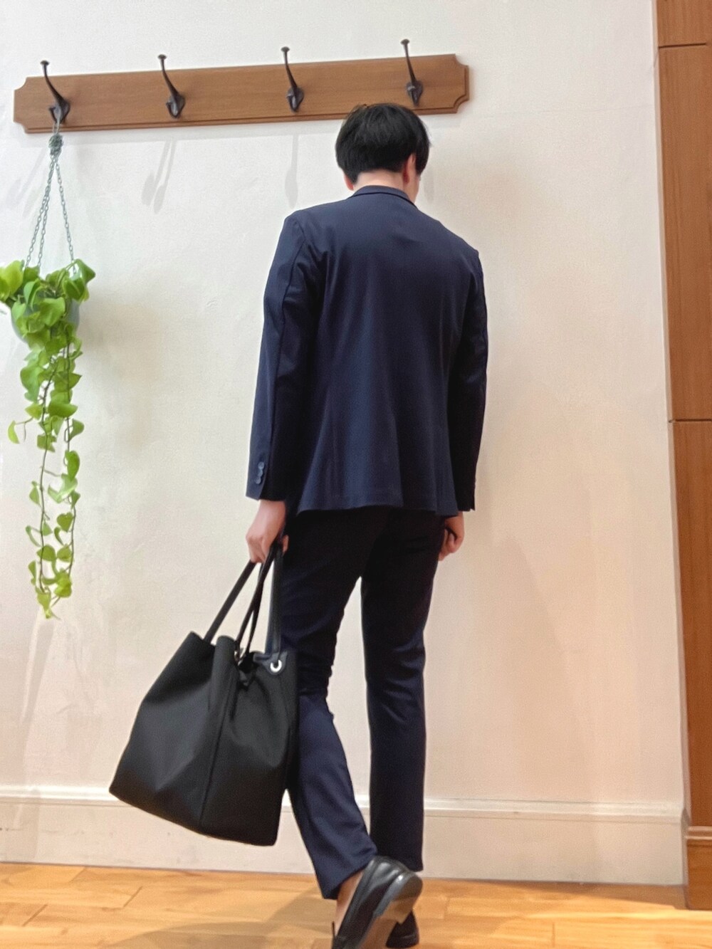 ブラック系のトートバッグ、ベージュ系のTシャツ/カットソー、ブルー系のテーラードジャケットを着用したメンズの春コーディネートの6枚目の写真