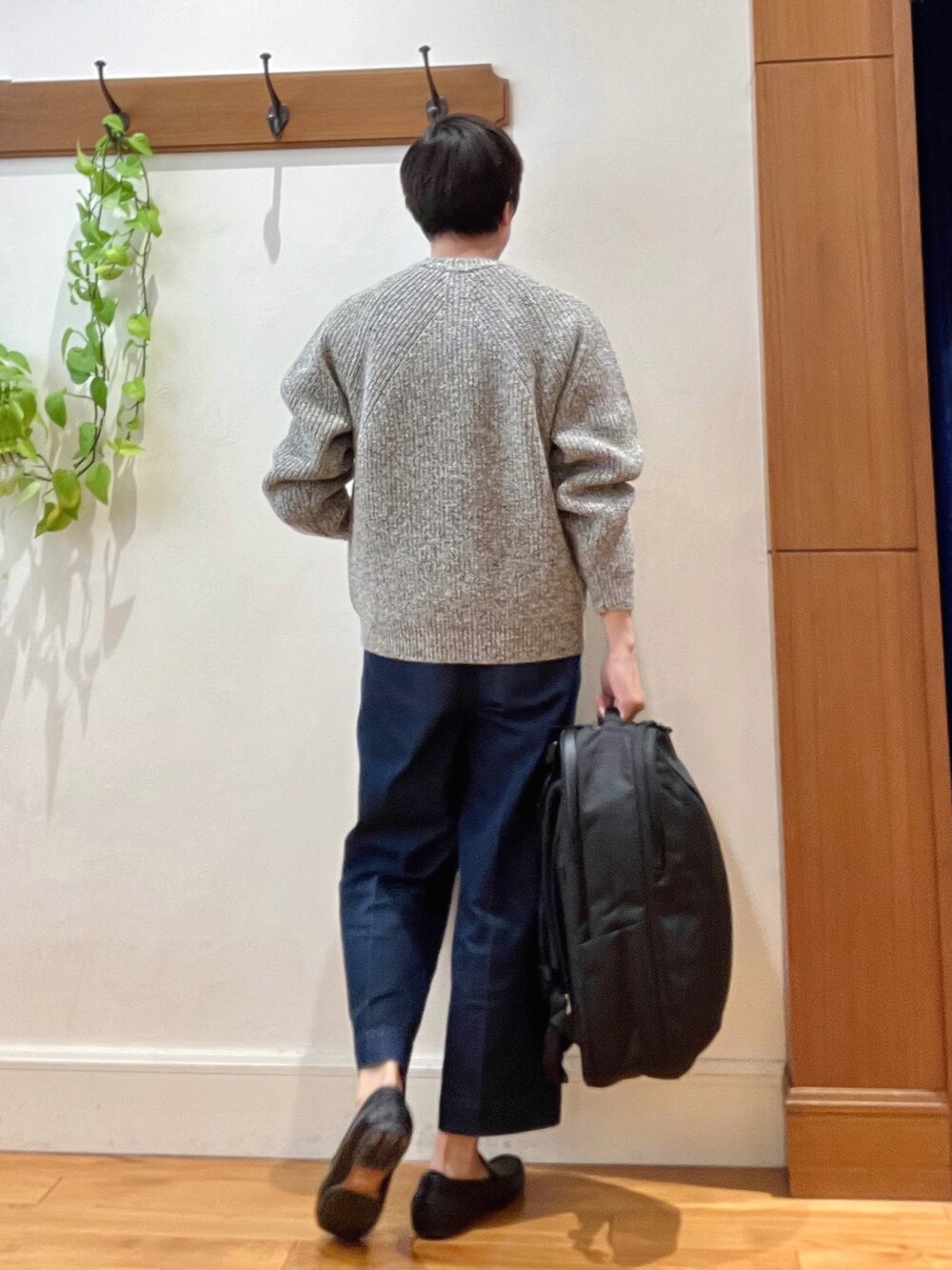 グレー系のニット/セーター、ブラック系のバックパック/リュックを着用したメンズの秋コーディネートの5枚目の写真
