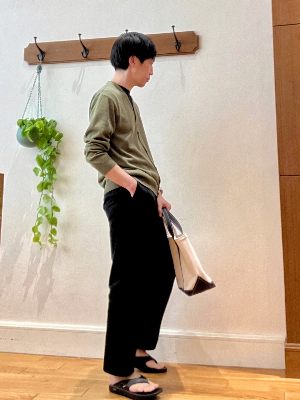 グリーン系のカーディガン/ボレロ、ブラック系のサンダル、ホワイト系のトートバッグを着用したメンズの春コーディネートの3枚目の写真