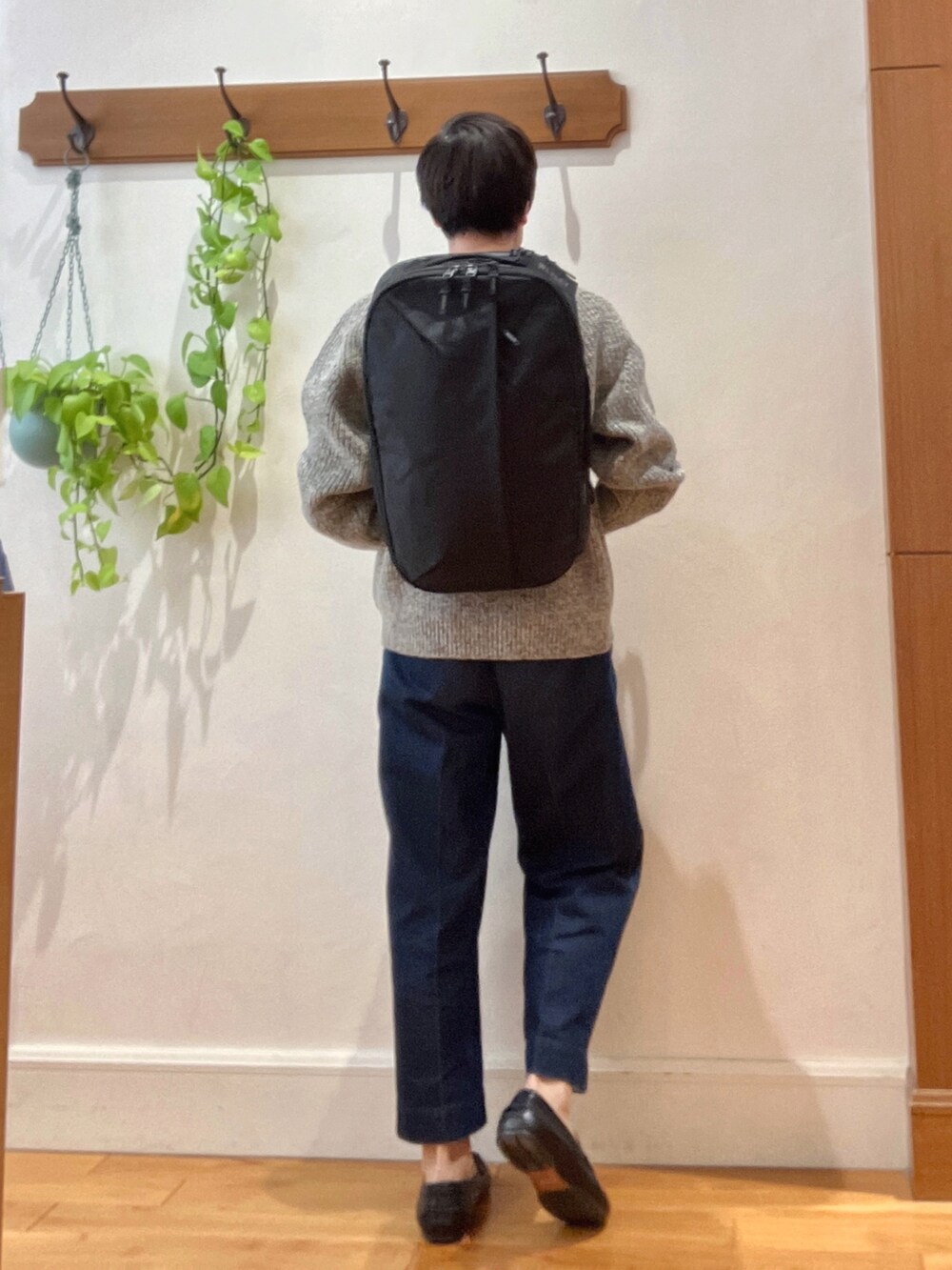 グレー系のニット/セーター、ブラック系のバックパック/リュックを着用したメンズの秋コーディネートの6枚目の写真
