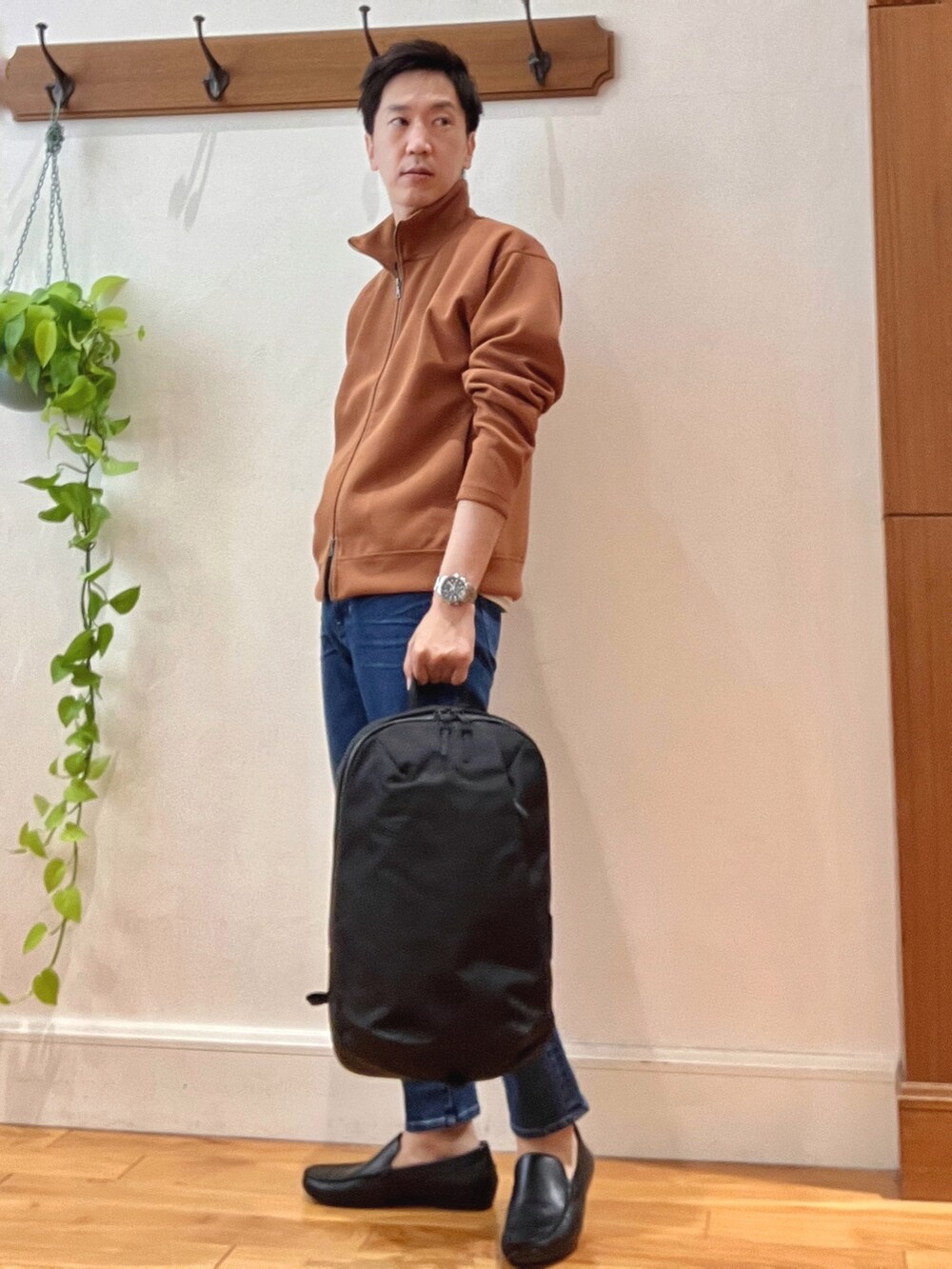 レッド系のカーディガン/ボレロ、ホワイト系のTシャツ/カットソー、ブラック系のバックパック/リュックを着用したメンズの秋コーディネートの3枚目の写真