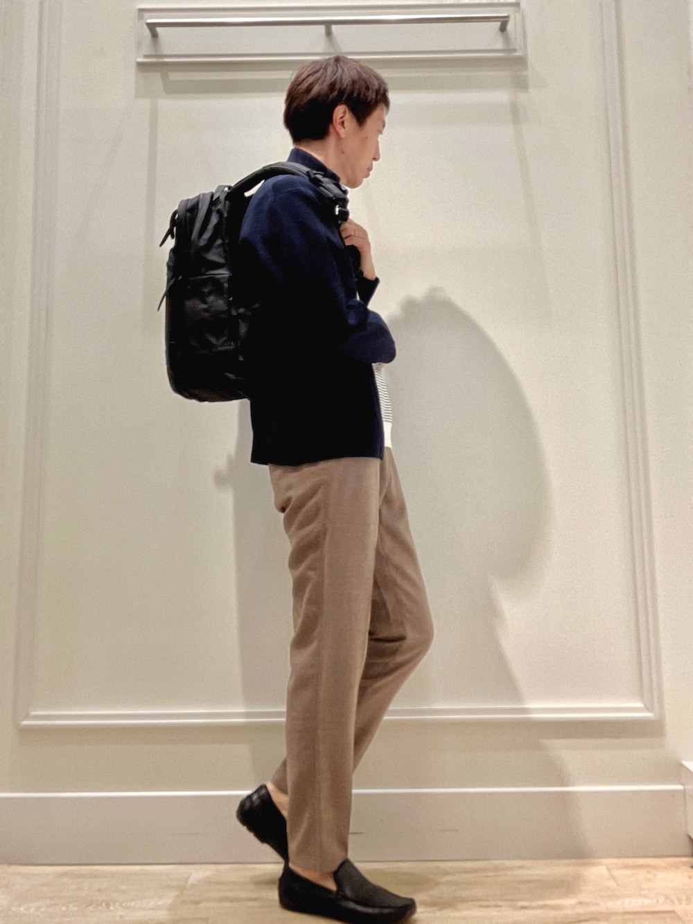 ブルー系のニット/セーター、ホワイト系のTシャツ/カットソー、ベージュ系のその他パンツを着用したメンズの冬コーディネートの5枚目の写真