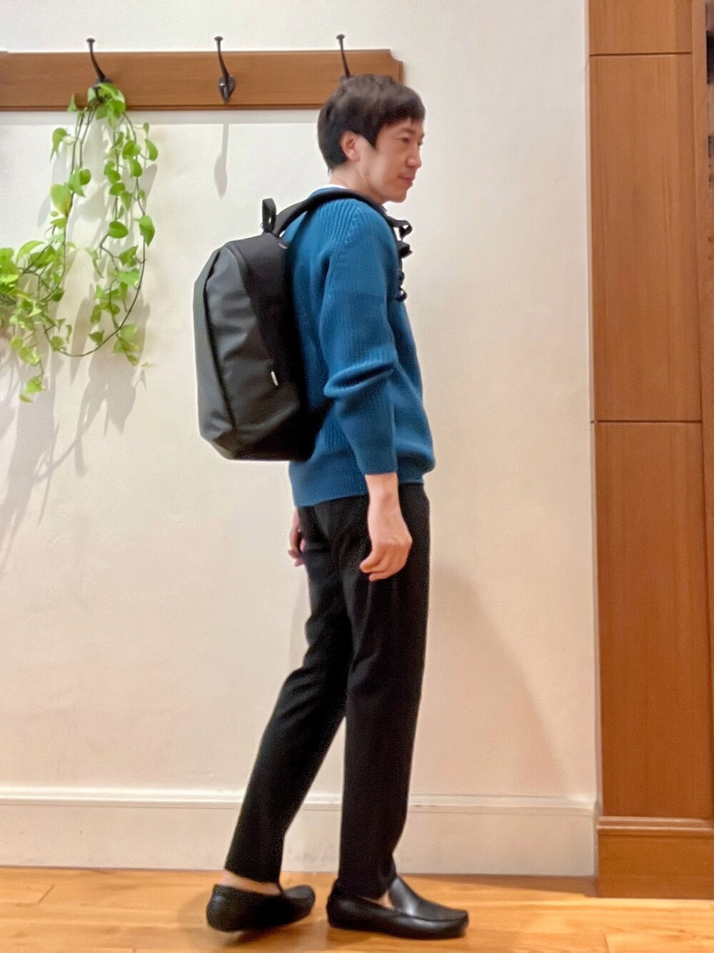 ブルー系のニット/セーター、グレー系のその他パンツ、グレー系のバックパック/リュックを着用したメンズの秋コーディネートの7枚目の写真