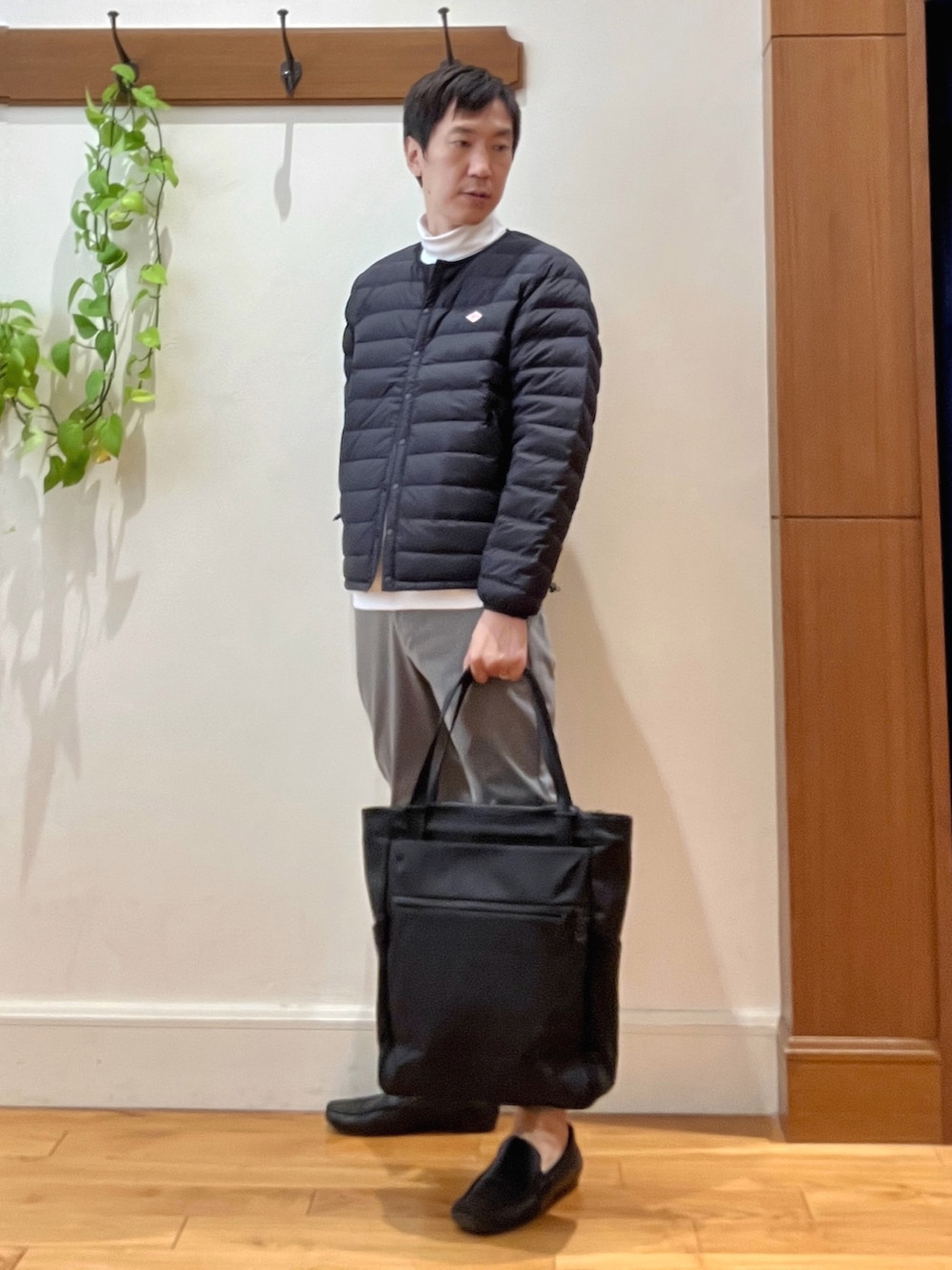 ブラック系のトートバッグ、グレー系のその他パンツ、ホワイト系のTシャツ/カットソーを着用したメンズの秋コーディネートの2枚目の写真