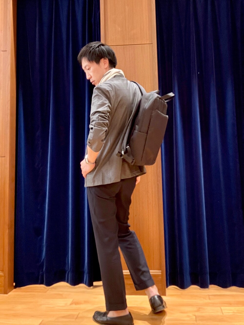 グレー系のノーカラージャケット、ホワイト系のTシャツ/カットソー、ブラック系のバックパック/リュックを着用したメンズの春コーディネートの5枚目の写真