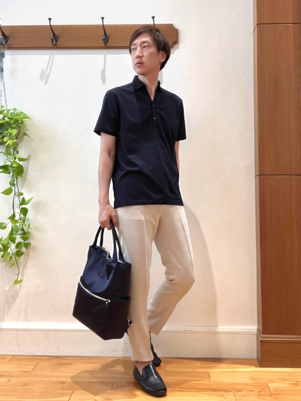 ブルー系のトートバッグ、ブルー系のポロシャツ、ホワイト系のその他パンツを着用したメンズの夏コーディネートの5枚目の写真