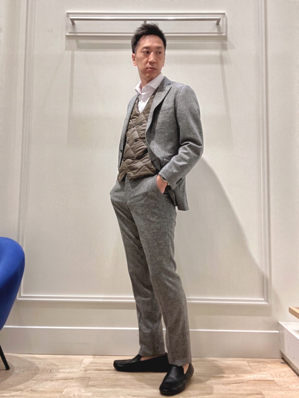 グレー系のテーラードジャケット、グレー系のスラックス、ブラック系のトートバッグを着用したメンズの秋コーディネートの7枚目の写真