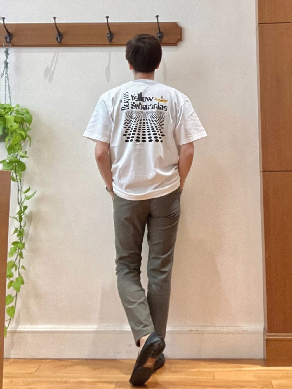 グリーン系のチノパンツ、ブラック系のショルダーバッグ、ホワイト系のTシャツ/カットソーを着用したメンズの春コーディネートの3枚目の写真