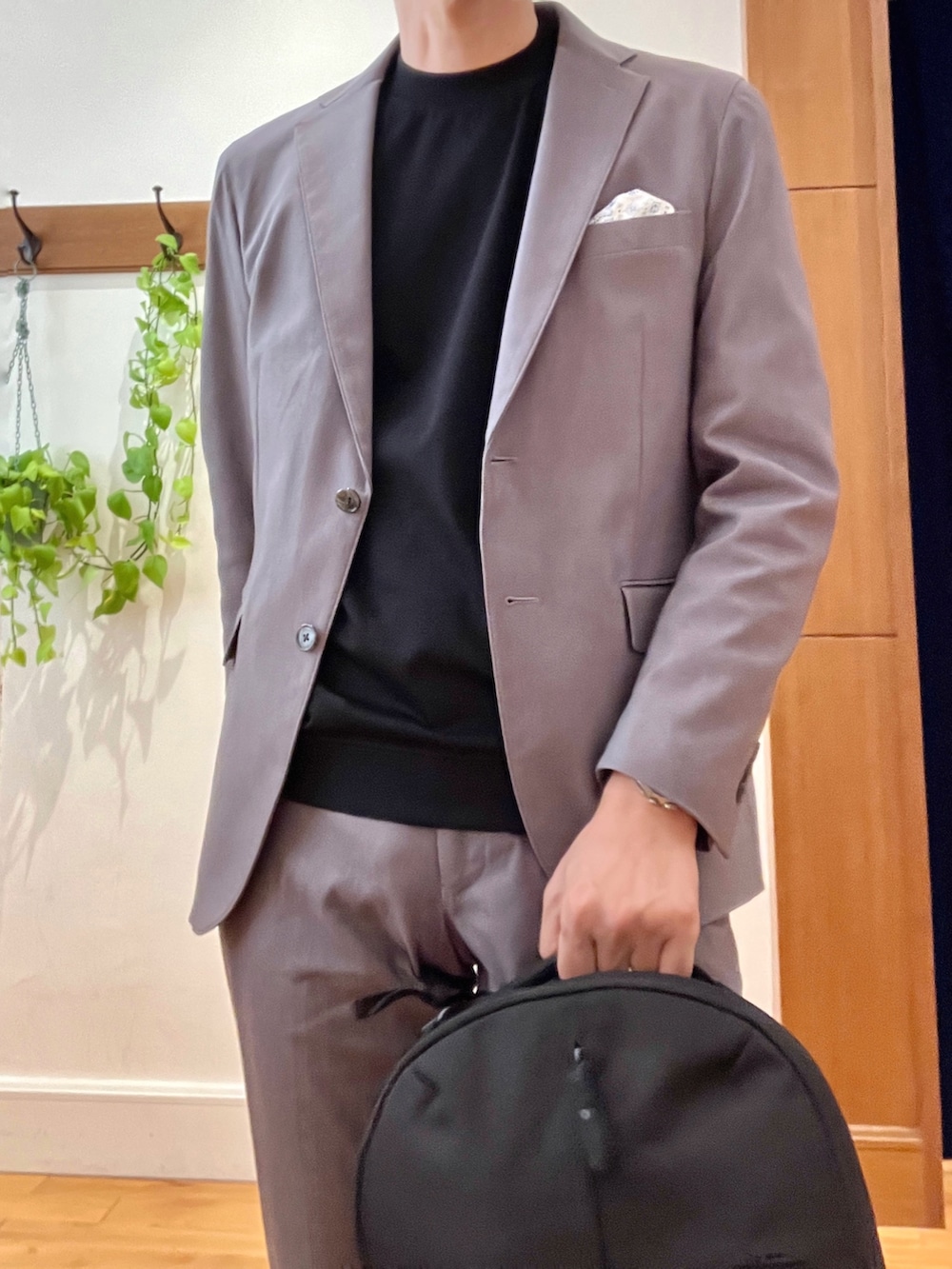 ブラック系のバックパック/リュック、ブラック系のTシャツ/カットソー、グレー系のテーラードジャケットを着用したメンズの秋コーディネートの8枚目の写真