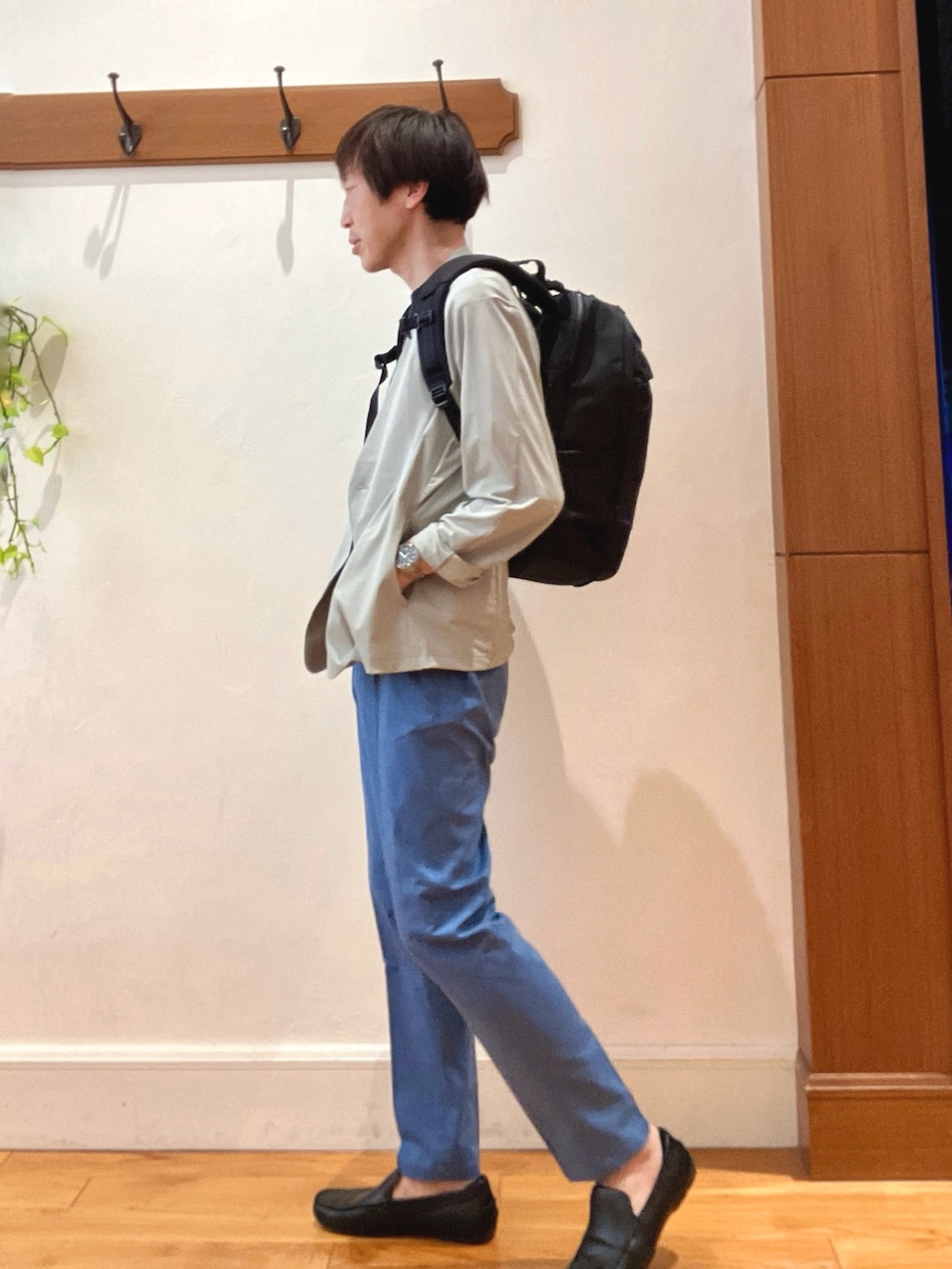 ブラック系のバックパック/リュック、ブルー系のチノパンツ、ブルー系のTシャツ/カットソーを着用したメンズの春コーディネートの2枚目の写真