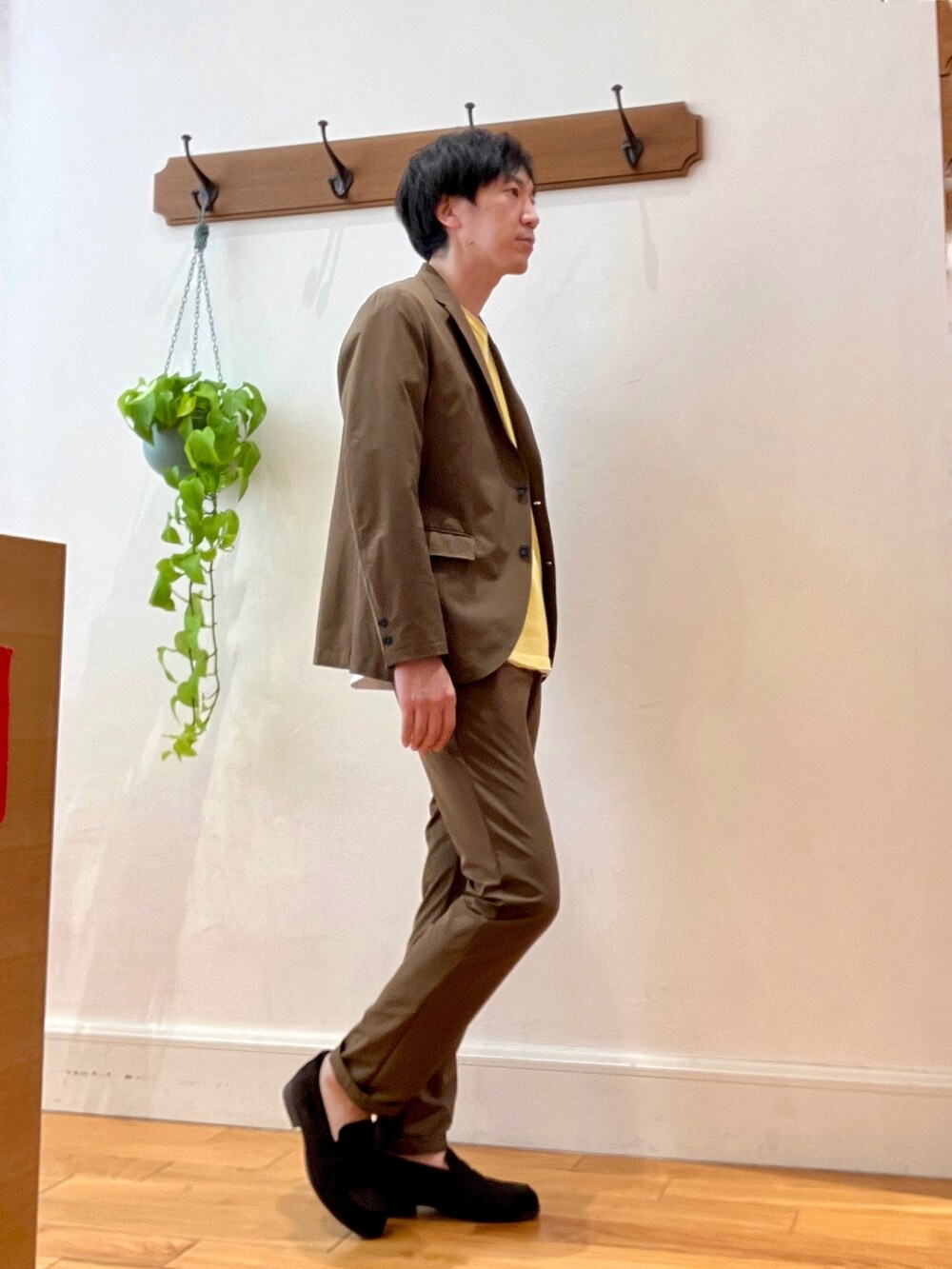 ブラウン系のローファー、ブラウン系のテーラードジャケット、イエロー系のニット/セーターを着用したメンズの冬コーディネートの6枚目の写真