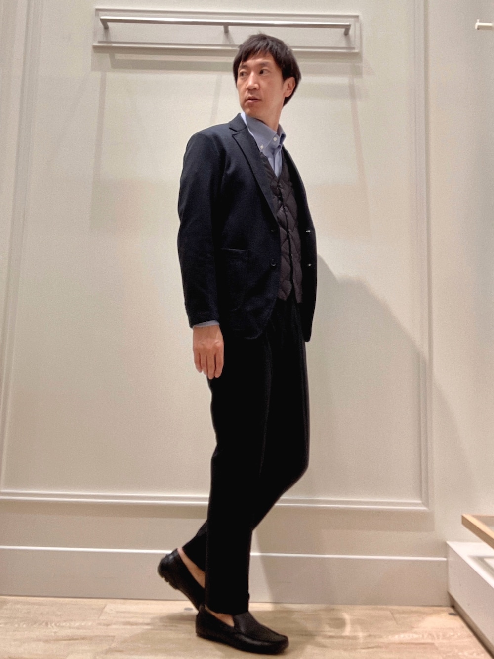 ブルー系のシャツ/ブラウス、ブルー系のテーラードジャケット、ブラック系のダウンベストを着用したメンズの秋コーディネートの7枚目の写真