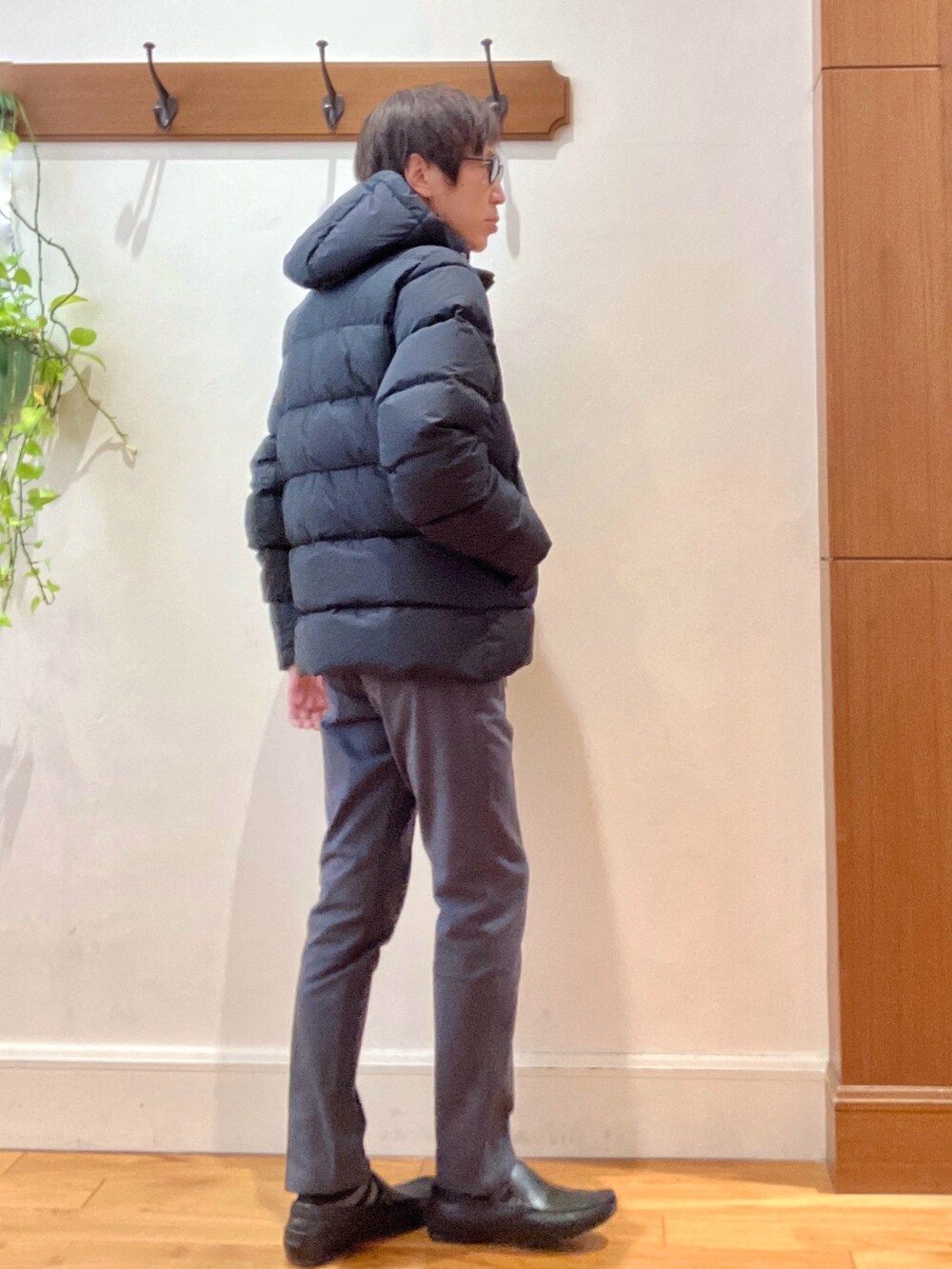 グレー系のチノパンツ、ブラック系のニット/セーター、ブラック系のダウンジャケット/コートを着用したメンズの冬コーディネートの5枚目の写真