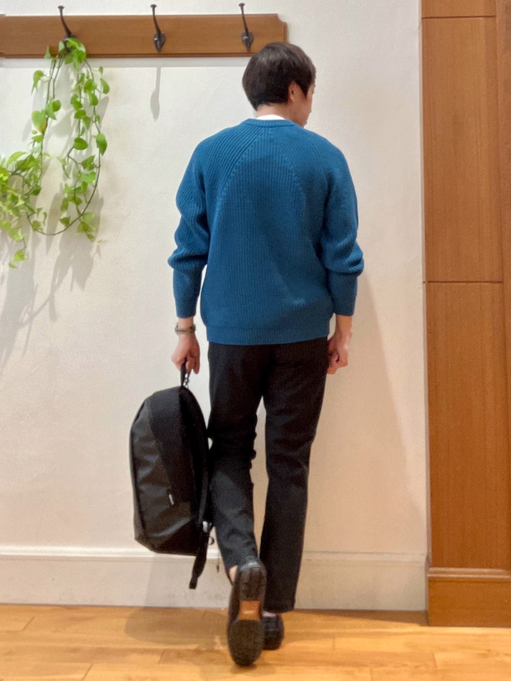 ブルー系のニット/セーター、グレー系のその他パンツ、グレー系のバックパック/リュックを着用したメンズの秋コーディネートの5枚目の写真