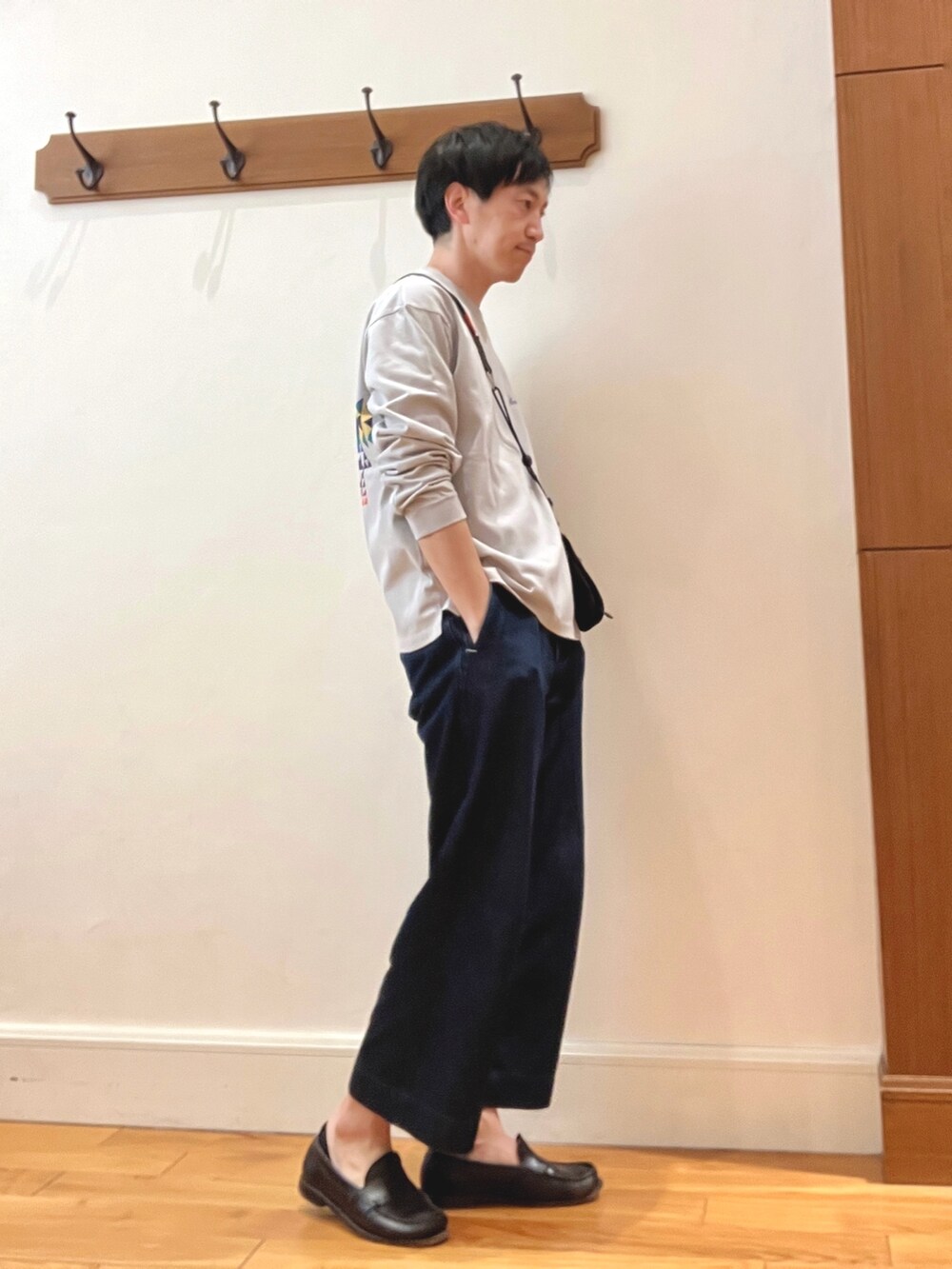 グレー系のTシャツ/カットソー、ブラック系のショルダーバッグ、ブラック系のスマホグッズを着用したメンズの春コーディネートの4枚目の写真