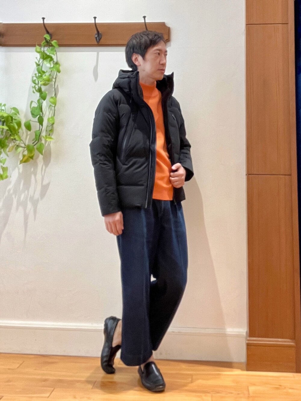 ブラック系のダウンジャケット/コート、オレンジ系のニット/セーターを着用したメンズの秋コーディネートの7枚目の写真