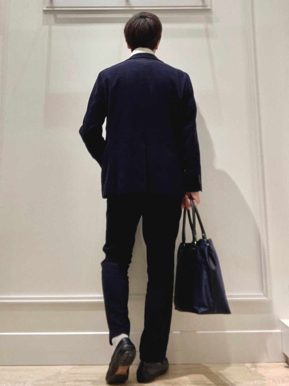 ホワイト系のニット/セーター、ブルー系のトートバッグを着用したメンズの冬コーディネートの4枚目の写真