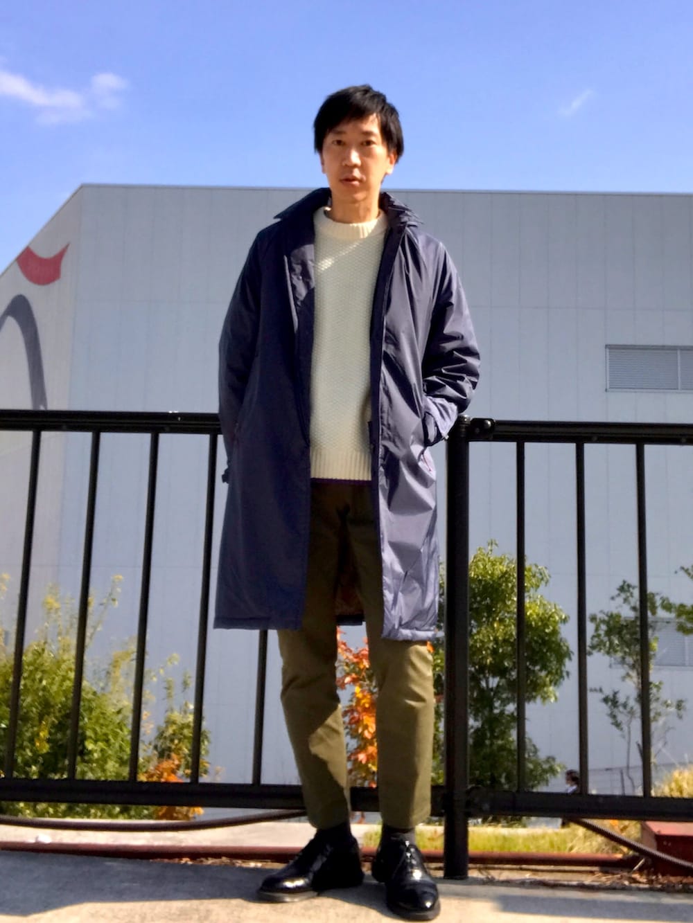 ブルー系のダウンジャケット/コート、ホワイト系のニット/セーター、グリーン系のチノパンツを着用したメンズの冬コーディネートの5枚目の写真