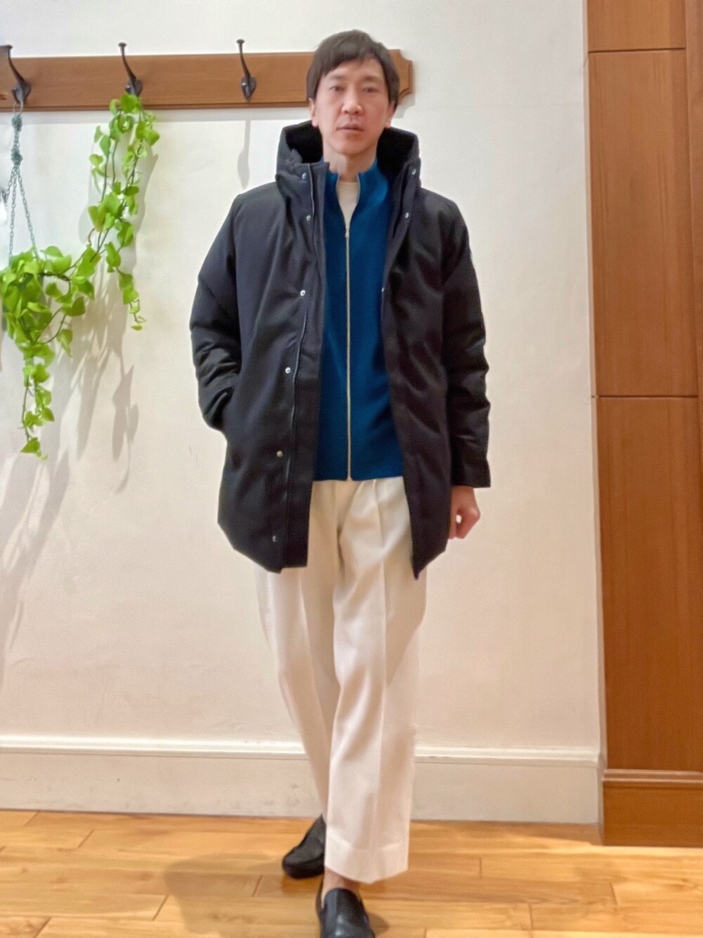 ホワイト系のTシャツ/カットソー、ブラック系のダウンジャケット/コート、ブルー系のカーディガン/ボレロを着用したメンズの冬コーディネートの8枚目の写真