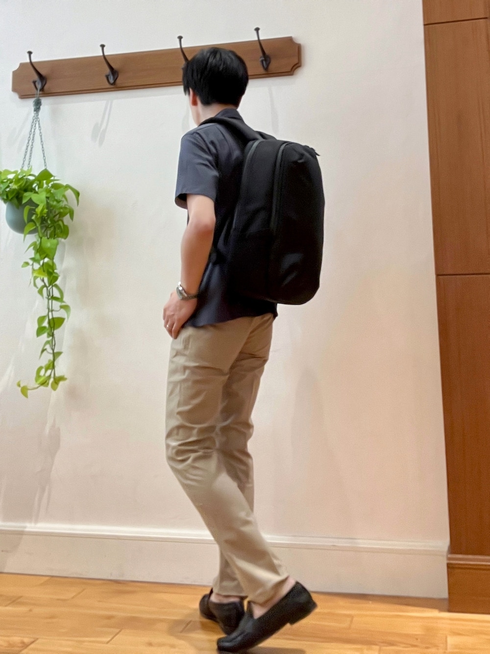 グレー系のポロシャツ、ブラック系のバックパック/リュック、ベージュ系のその他パンツを着用したメンズの春コーディネートの4枚目の写真