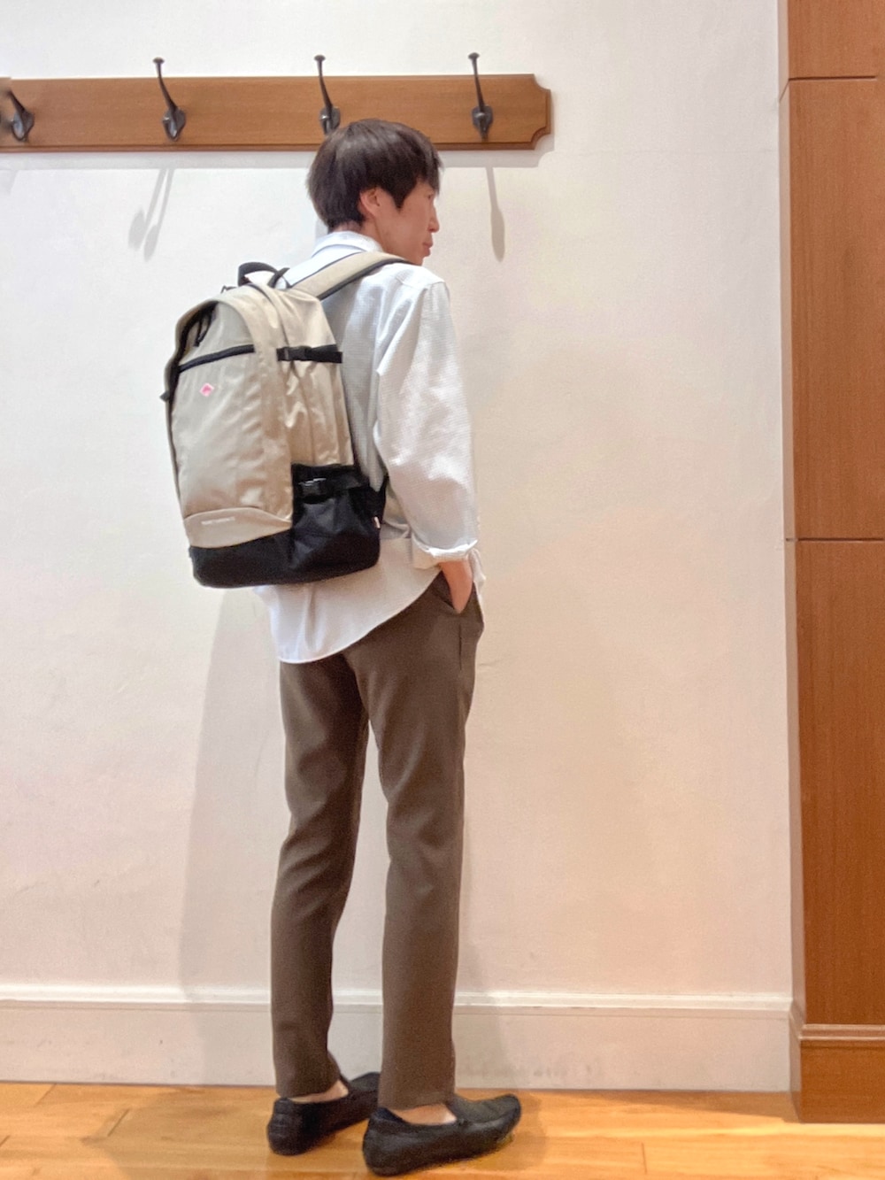 ホワイト系のシャツ/ブラウス、ベージュ系のバックパック/リュック、ブラウン系のその他パンツを着用したメンズの春コーディネートの6枚目の写真