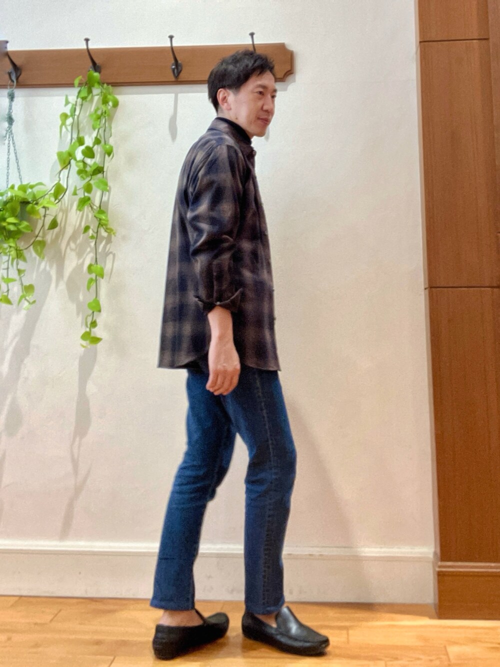 グリーン系のシャツ/ブラウス、ブルー系のニット/セーター、ブルー系のデニムパンツを着用したメンズの冬コーディネートの6枚目の写真