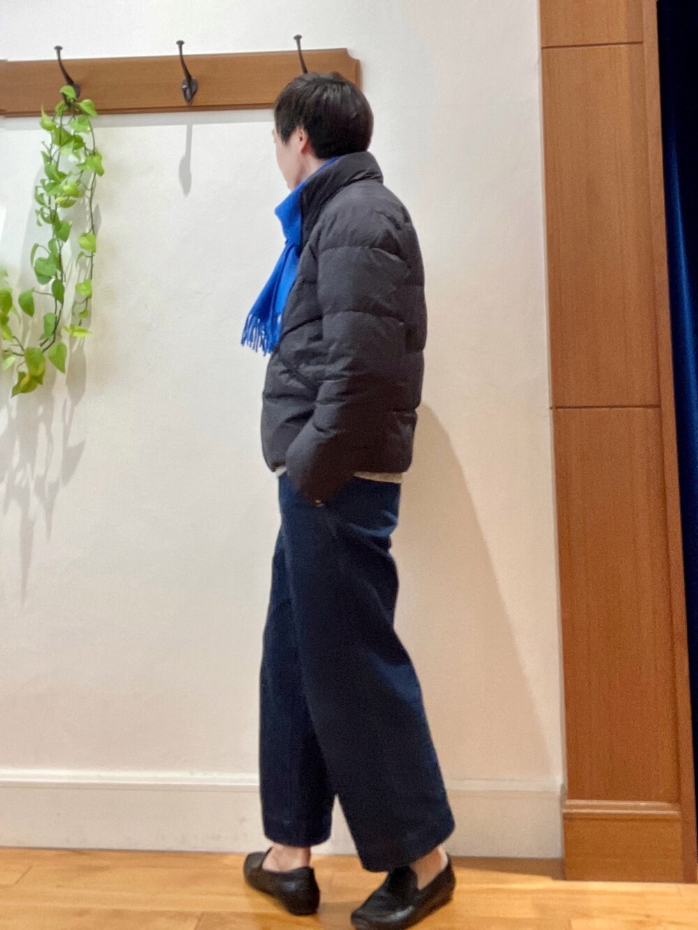 グリーン系のダウンジャケット/コート、ブルー系のニット/セーター、ブルー系のマフラーを着用したメンズの秋コーディネートの4枚目の写真