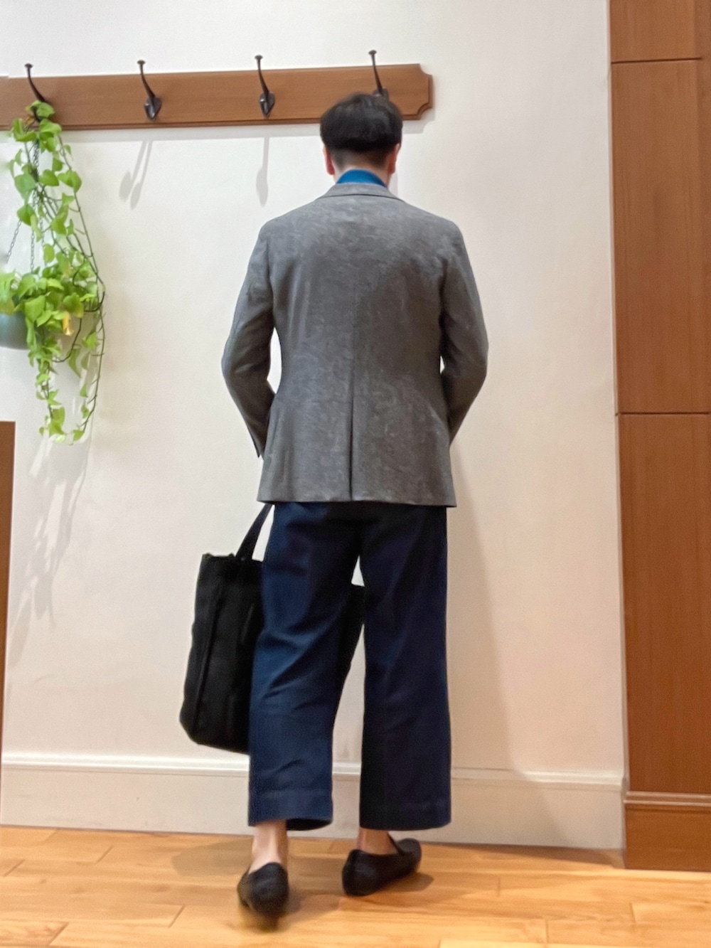 グレー系のテーラードジャケット、ブルー系のニット/セーター、ブラック系のトートバッグを着用したメンズの冬コーディネートの4枚目の写真