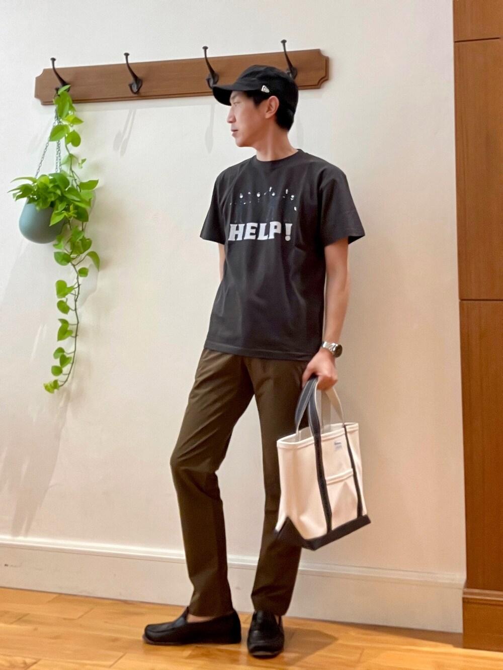 ブラック系のTシャツ/カットソー、ホワイト系のトートバッグ、ブラウン系のその他パンツを着用したメンズの春コーディネートの2枚目の写真