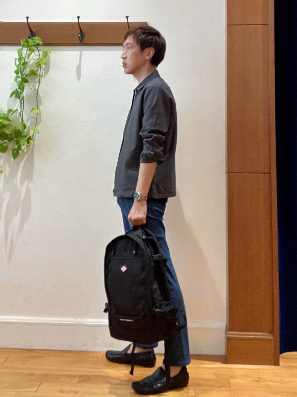 ブラック系のバックパック/リュック、ブルー系のデニムパンツ、ブラック系のTシャツ/カットソーを着用したメンズの夏コーディネートの3枚目の写真