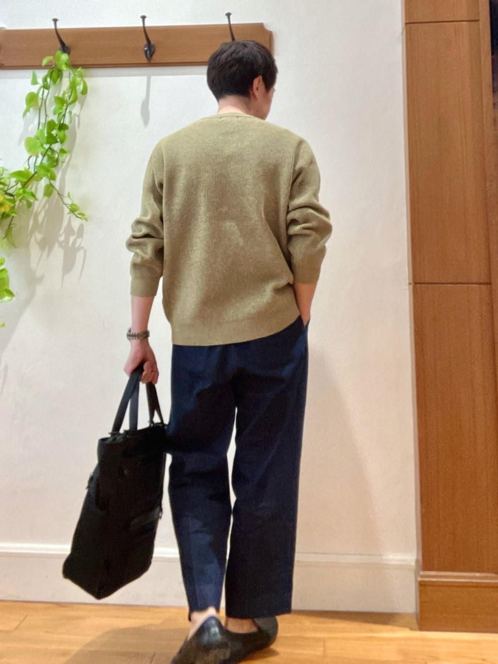 イエロー系のニット/セーター、ブルー系のデニムパンツ、ブラック系のトートバッグを着用したメンズの冬コーディネートの5枚目の写真