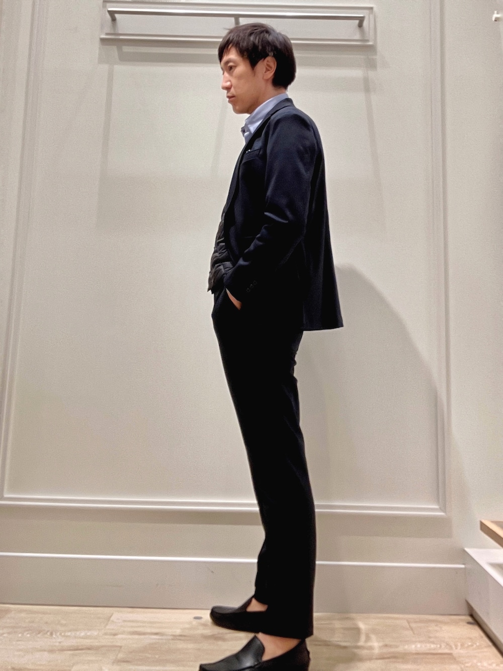 ブルー系のシャツ/ブラウス、ブルー系のテーラードジャケット、ブラック系のダウンベストを着用したメンズの秋コーディネートの4枚目の写真