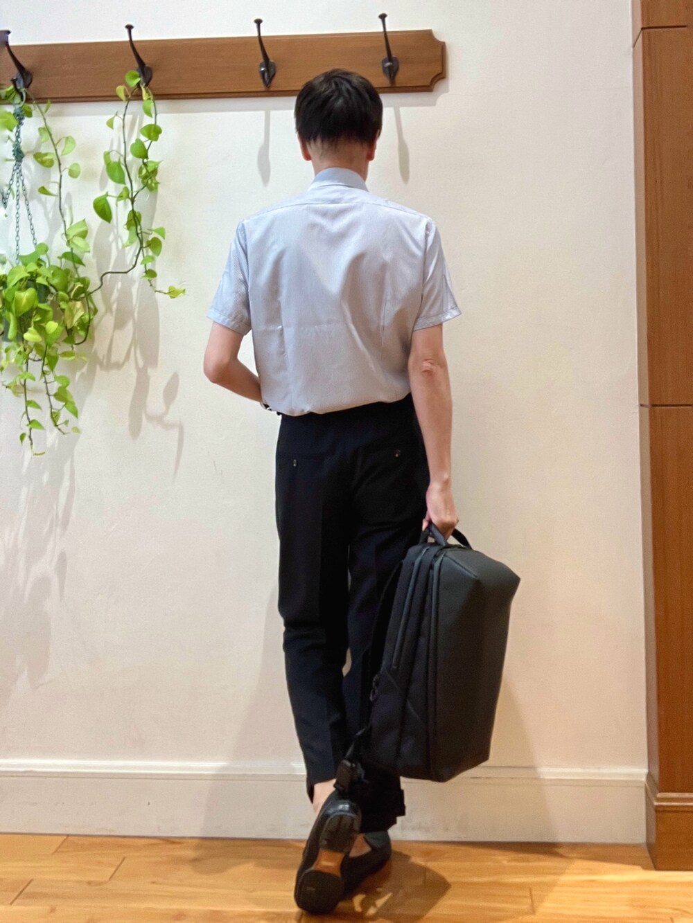 ブラック系のスラックス、ブルー系のビジネスシャツ、ブラック系のバックパック/リュックを着用したメンズの夏コーディネートの4枚目の写真