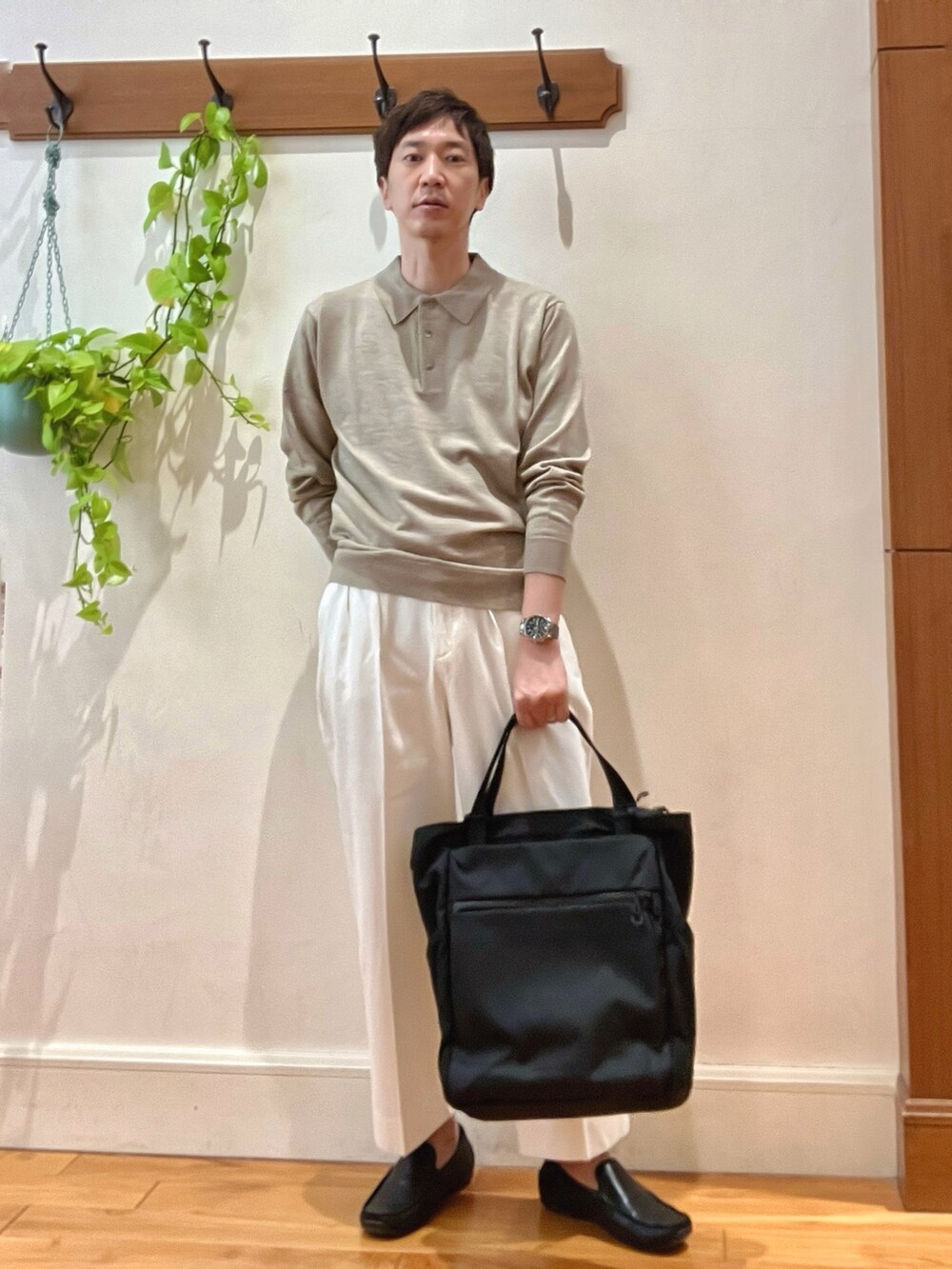 ホワイト系のデニムパンツ、ブラック系のトートバッグ、ベージュ系のニット/セーターを着用したメンズの冬コーディネートの9枚目の写真