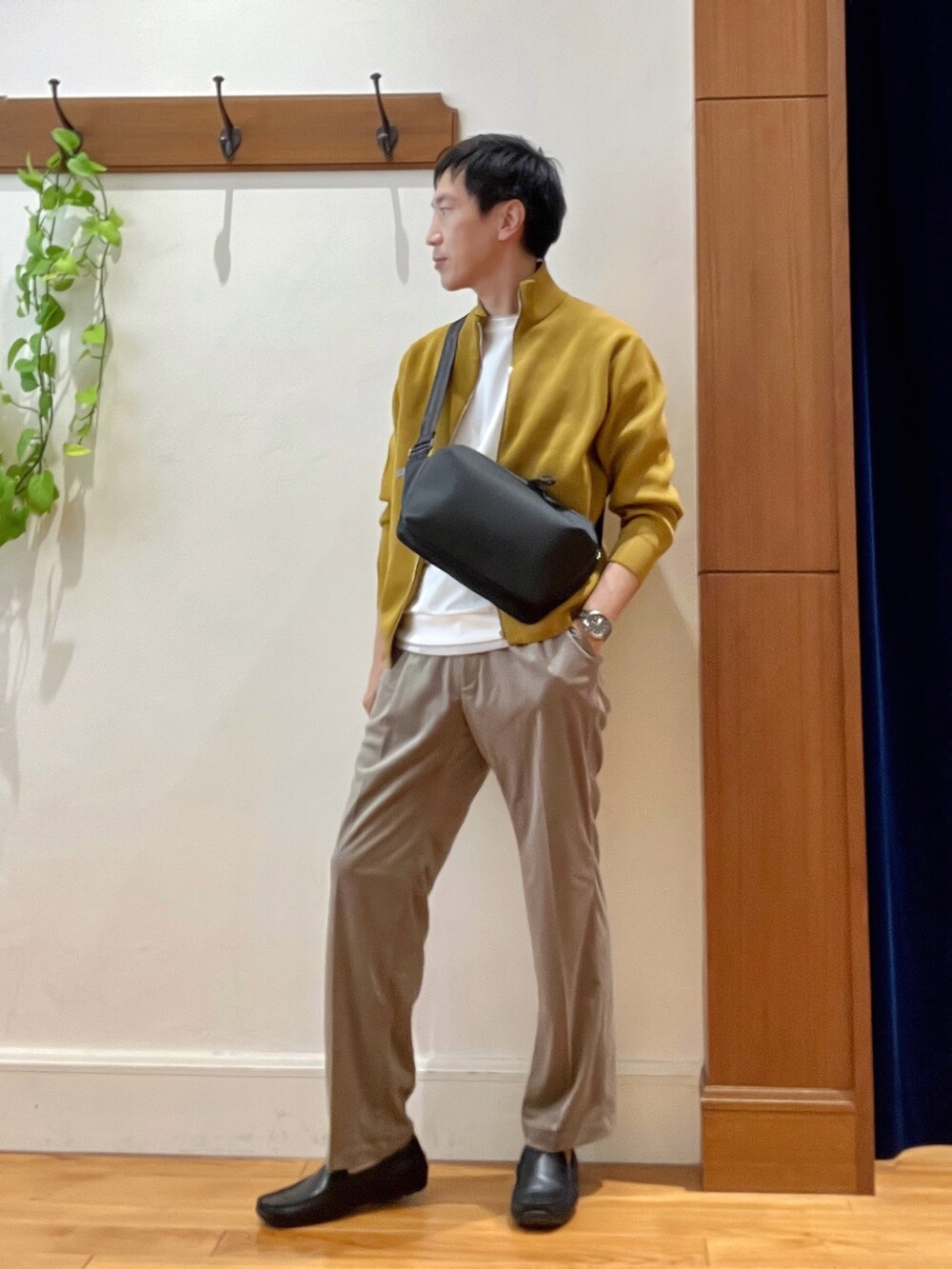 イエロー系のニット/セーター、ホワイト系のTシャツ/カットソー、ブラック系のショルダーバッグを着用したメンズの秋コーディネートの2枚目の写真