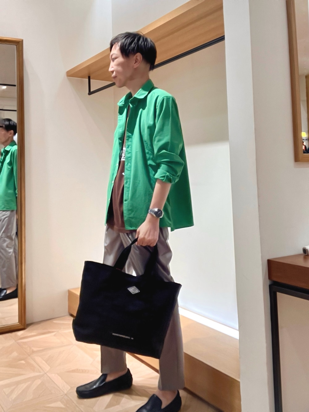 グリーン系のシャツ/ブラウス、ブラウン系のTシャツ/カットソー、ブラック系のトートバッグを着用したメンズの夏コーディネートの3枚目の写真