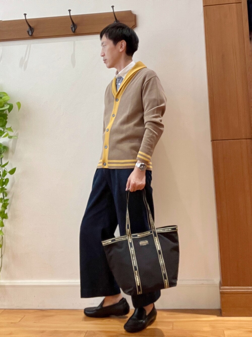 ブルー系のシャツ/ブラウス、ベージュ系のカーディガン/ボレロ、ブラック系のトートバッグを着用したメンズの秋コーディネートの3枚目の写真