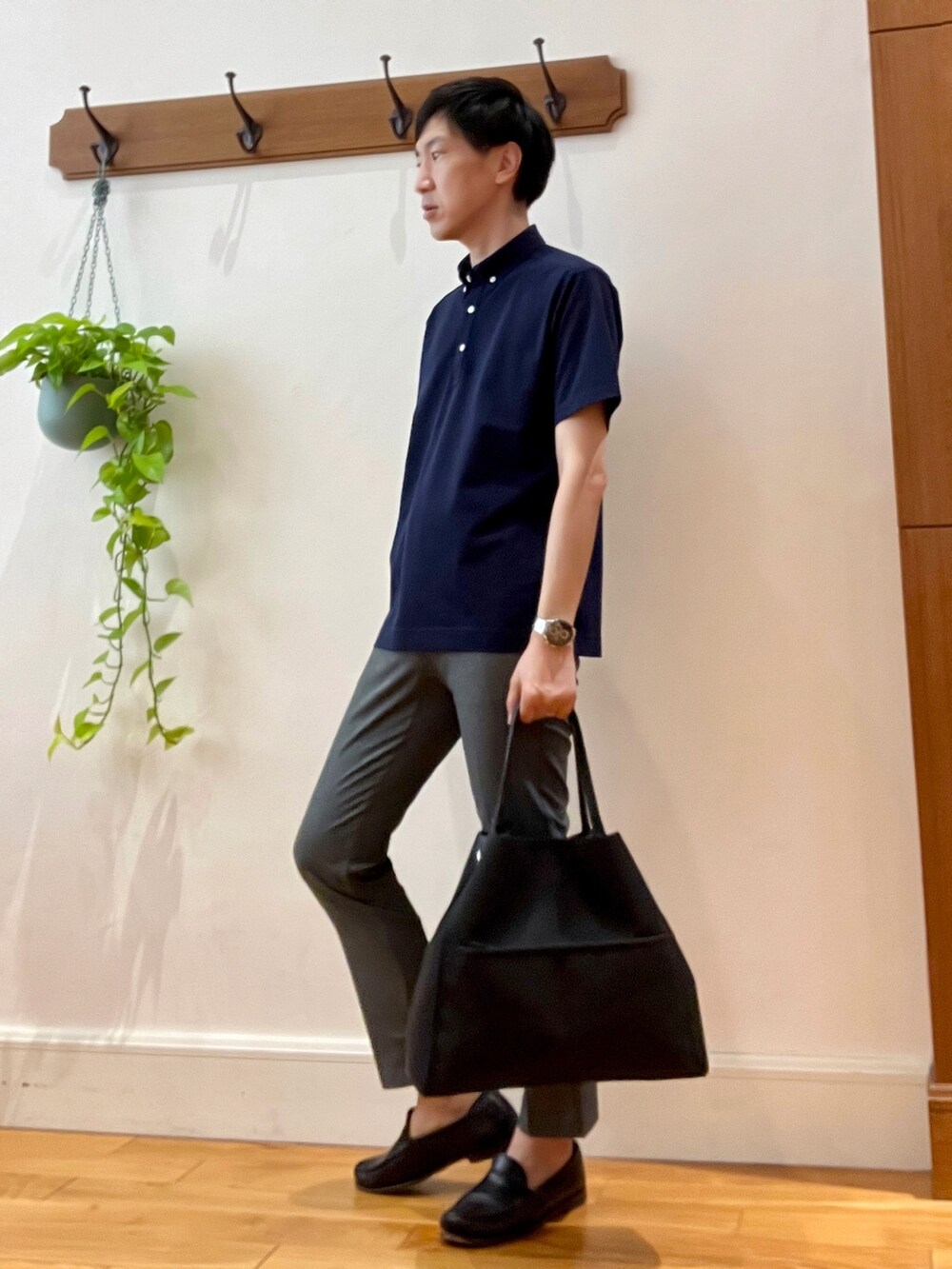 グレー系のその他パンツ、ブルー系のポロシャツ、ブラック系のトートバッグを着用したメンズの春コーディネートの2枚目の写真