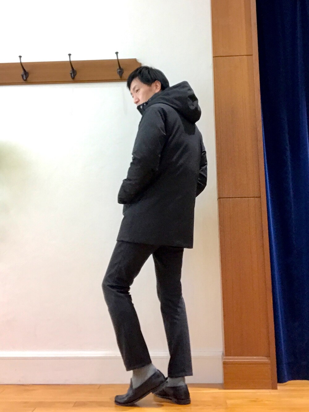 ブラック系のダウンジャケット/コート、ブルー系のニット/セーター、グレー系のその他パンツを着用したメンズの冬コーディネートの4枚目の写真