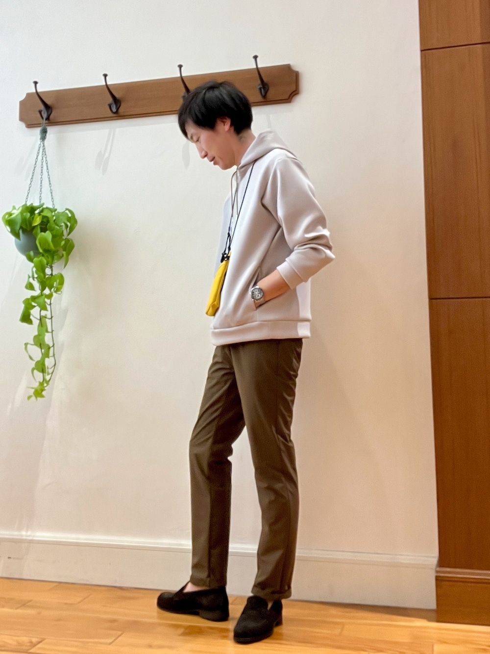ベージュ系のパーカー、イエロー系のショルダーバッグ、ブラウン系のその他パンツを着用したメンズの冬コーディネートの5枚目の写真